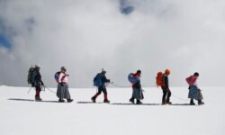 Para Cholita, menuruni gunung Huayna Potosi bersama suami mereka, yang bekerja sebagai pemandu profesional, di pinggiran El Alto, Bolivia, 17 Desember 2015. (AP)