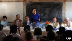 Myanmar opposition leader Aung San Suu Kyi (center) speaks to villagers near a Chinese-backed copper mine project, in Monywa northern Myanmar on March 13, 2013. 