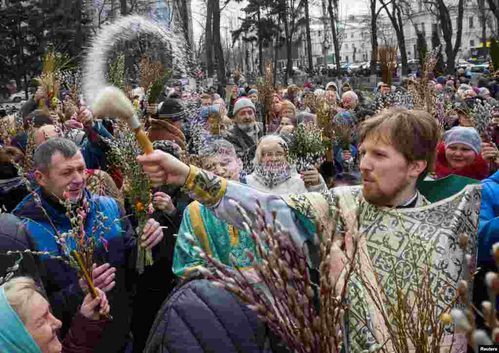 An Orthodox priest sprays holy water as believers mark Palm Sunday in Kyiv, Ukraine.