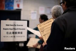 People wait in line to cast their ballots to vote in the New York primary elections at a polling station in the Brooklyn borough of New York City, April 19, 2016.