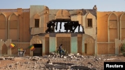 A man walks past the destroyed former customs building, which was used as a base by radical Islamists, in Gao, Mali, February 28, 2013.