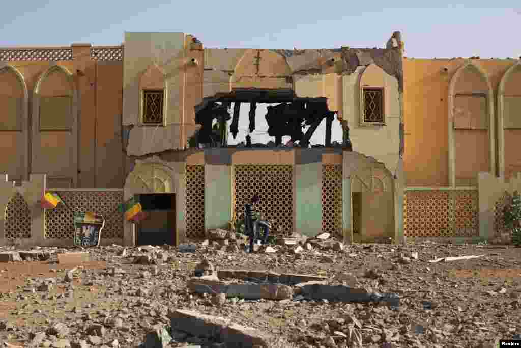 A man walks past the destroyed former customs building, which was used as a base by radical Islamists, in Gao, Mali.