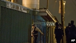 Members of the Mexican Federal Police stand guard in front of a rehab center in Tijuana, where the shootings occured, 25 October 2010