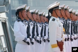 Chinese People's Liberation Army Navy troops stand in formation on the deck of a type 054A guided missile frigate "Wuhu" as it docks at Manila's South Harbor for a four-day port call, Jan. 17, 2019 in Manila, Philippines.