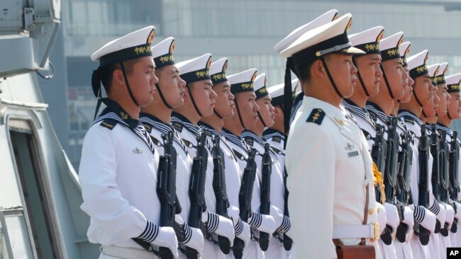 Chinese People's Liberation Army Navy troops stand in formation on the deck of a type 054A guided missile frigate "Wuhu" as it docks at Manila's South Harbor for a four-day port call, Jan. 17, 2019 in Manila, Philippines. 