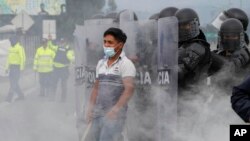 Un manifestante se para en medio de una nube de gases lacrimógenos en el primer día de una huelga nacional para protestar por el aumento de los precios de la gasolina y las políticas del presidente de Ecuador, Guillermo Lasso, en Saquisilí, Ecuador, el martes 26 de octubre.