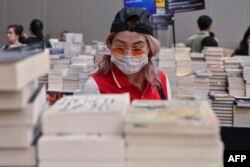 Seorang pengunjung pameran buku di Jakarta mengenakan masker untuk melindungi dari penularan virus corona, 8 Maret 2020. (Foto: AFP)