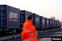 A worker looks at the first freight train to travel from China to Britain during a welcoming ceremony to mark the inaugural trip at at Barking Intermodal Terminal near London, Jan. 18, 2017.