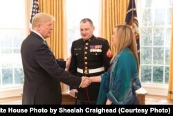 President Donald Trump welcomes State of the Union honored guests U.S. Marine Cpl. (Ret.) Matthew Bradford, and his wife and child, to the Oval Office at the White House, in Washington, Jan. 30, 2018.