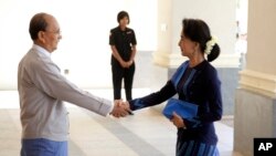 FILE - Myanmar President Thein Sein, left, shakes hands with Myanmar opposition leader Aung San Suu Kyi as they meet at Myanmar Presidential Palace in Naypyitaw, Myanmar, Oct 31, 2014. 