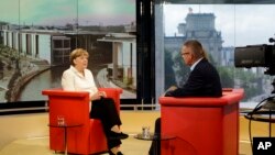 Kanselir Jerman Angela Merkel (kiri) dalam sebuah wawancara di studio ARD, di Berlin, Jerman (19/7).