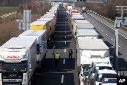 Trucks stand on the highway close to the border between Austria and Hungary near Bruck an der Leitha, Austria, Wednesday, March 18, 2020. Hungary has closed the border due to the new coronavirus outbreak. (AP Photo/Ronald Zak)