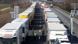 Trucks stand on the highway close to the border between Austria and Hungary near Bruck an der Leitha, Austria, Wednesday, March 18, 2020. Hungary has closed the border due to the new coronavirus outbreak. (AP Photo/Ronald Zak)