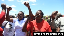 FILE: Zimbabwean war veterans who had gathered to demonstrate against a faction within the ruling Zanu PF party, reportedly led by the First Lady Grace Mugabe, vent their anger after they were dispersed by police using tear gas and water cannons in Harare, Thursday, Feb. 18, 2016. Mugabe was instrumental in the ouster of Zimbabwes first deputy President Joice Mujuru in 2014. (AP Photo/Tsvangirayi Mukwazhi)