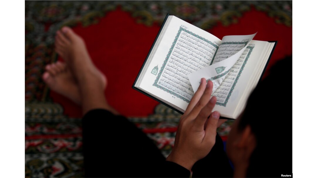 Seorang anak laki-laki membaca Alquran menjelang berakhirnya bulan suci Ramadan, di sebuah masjid di Jakarta, 3 Juni 2019. (Foto: Reuters)