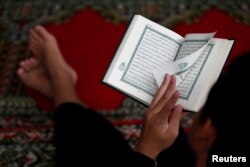 Seorang anak laki-laki membaca Alquran menjelang berakhirnya bulan suci Ramadan, di sebuah masjid di Jakarta, 3 Juni 2019. (Foto: Reuters)