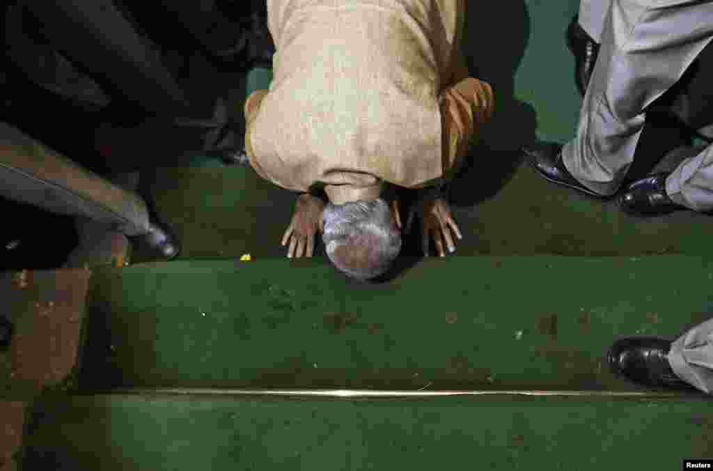 Thủ tưởng tân cử Narendra Modi, nhân vật theo chủ trương dân tộc Hindu, quỳ mọp tỏ lòng tôn kính trên những bậc thang của tòa nhà quốc hội khi đến dự cuộc họp quốc hội của Đảng Bharatiya Janata tại New Delhi.
