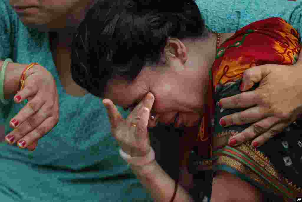 The wife of Laxman Neupane, one of the police officers killed in clashes in western Nepal, mourns after his body was brought to Kathmandu. Ethnic protesters, demanding statehood, attacked police with spears and knives in Tikapur, 400 kilometers (250 miles) west of the capital.