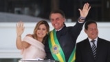 Presiden Brazil, Jair Bolsonaro didampingi ibu negara, Michelle Bolsonaro, di Istana Planalto usai pelantikan di Brasilia, Brazil, 1 Januari 2019.
