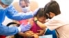 Un niño consuela a su hermanita después de recibir una dosis de una vacuna contra COVID-19 en Montevideo, Uruguay, el 12 de enero de 2022.