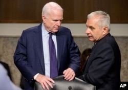 Senate Armed Service Committee Chairman John McCain, R-Ariz., left, talks with committee's ranking member Jack Reed, D-R.I., on Capitol Hill in Washington, July 29, 2015.
