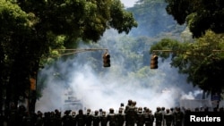 Polisi anti huru-hara mengambil posisi saat berhadapan dengan para pendukung oposisi dalam aksi unjuk rasa menentang Presiden Nicolas Maduro di Caracas, Venezuela, 4 Mei 2017.(REUTERS/Carlos Garcia Rawlins)