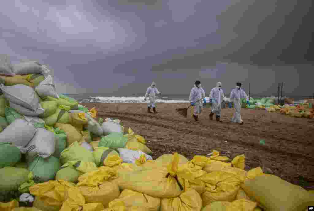 Sri Lankan navy soldiers look for plastic debris washed ashore from fire-damaged container ship MV X-Press Pearl at Kapungoda, on the outskirts of Colombo.