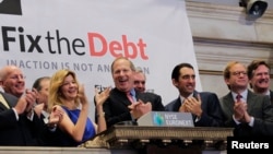 FILE - Maya MacGuineas, president of the Committee for a Responsible Federal Budget, and David Cote, (C) CEO of Honeywell International and part of the steering committee of the Campaign to Fix the Debt, are joined by supporters to ring the opening bell at the New York Stock Exchange, Oct. 25, 2012. 