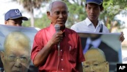 Chum Mey, center, a survivor of the Khmer Rouge's notorious S-21 prison speaks to the students in front of the portrait posters of Khieu Samphan, left, former head of state, and Ieng Sary, former foreign minister, during a public forum in Phnom Penh, Cambodia, Friday, Nov. 18, 2011. Hundreds of students attended at the public forum of the U.N.-backed genocide tribunal prior to the start of the former Khmer Rouge leaders trial which is scheduled to begin Nov. 21.(AP Photo/Heng Sinith)