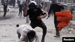 Polisi Mesir memukuli seorang demonstran dalam aksi protes anti pemerintah di Lapangan Tahrir, Kairo (foto: dok). Pemukulan demonstran oleh polisi memicu kemarahan nasional.