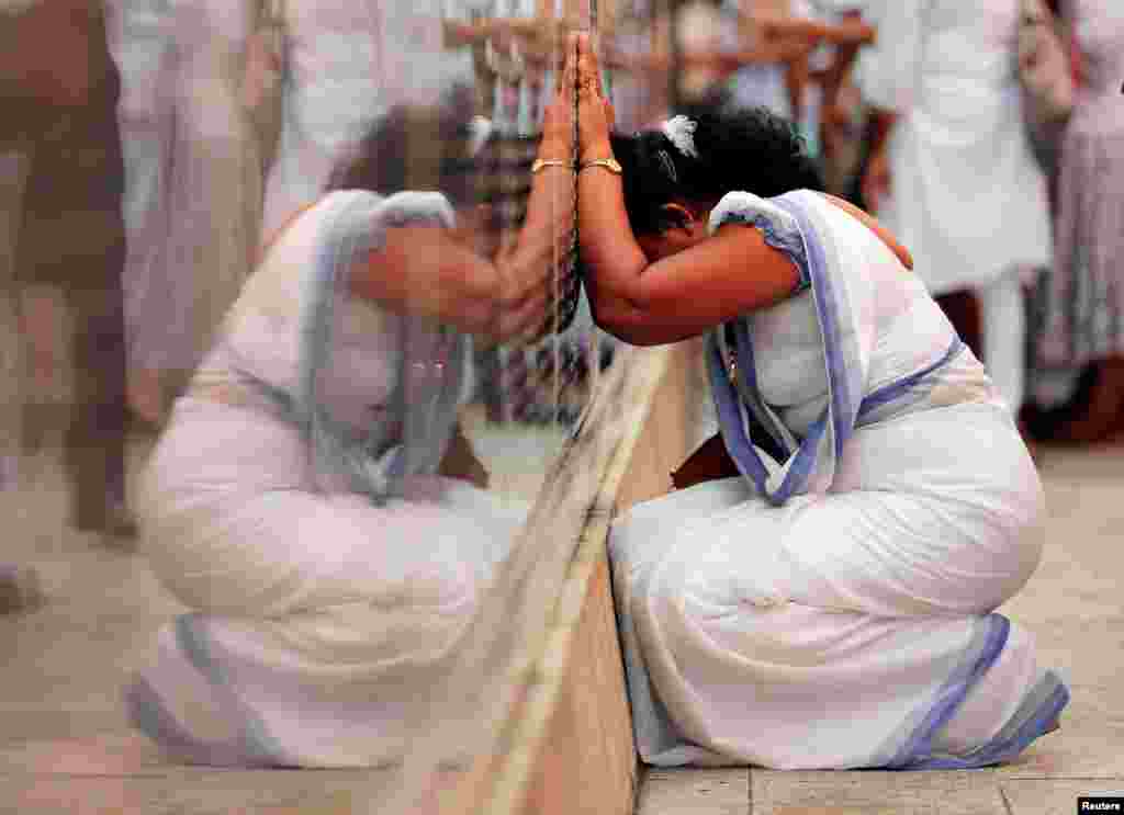 A family member of a soldier who died in the civil war, cries at the war memorial, during a commemoration ceremony to mark the 10th anniversary of the end of the armed conflict between Tamil Tigers and government troops, in Colombo, Sri Lanka.