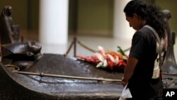 Una mujer reza junto a la tumba del asesinado monseñor Oscar Arnulfo Romero, en la catedral nacional en San Salvador, El Salvador.