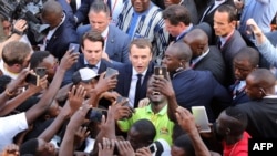 French President Emmanuel Macron (C) meets residents as he leaves the Ouagadougou University after giving a speech, Nov. 28, 2017, in Ouagadougou, as part of his first African tour since taking office.