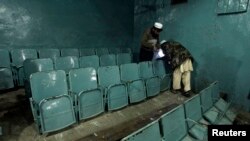 Petugas keamanan mengumpulkan bukti dari dalam bioskop tempat ledakan bom di Peshawar (2/2). (Reuters/Fayaz Aziz)