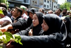 FILE - Iranians attend the funeral of victims of an Islamic State militant attack, in Tehran, Iran, June 9, 2017. Attacks during the week, claimed by Islamic State, killed 17 people.