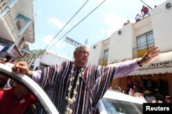FILE - Leftist front-runner Andres Manuel Lopez Obrador of the National Regeneration Movement (MORENA) waves to supporters after a campaign rally in Tlapa de Comonfort, in Guerrero state, Mexico, June 7, 2018.