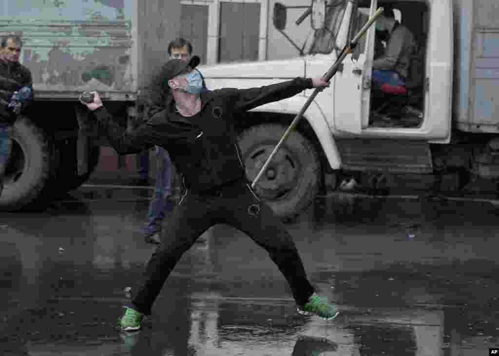 A pro-Russian protester throws a stone at a police station, in Odessa, May 4, 2014.