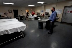 Pemilik rumah duka, Brian Simmons, mengawasi para karyawannya mempersiapkan jenazah untuk pemakaman di Springfield, 28 Januari 2021. (Foto: AP)