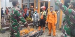 Petugas SAR dari Basarnas Makassar bersama personil TNI, mengevakuasi 2 jenazah korban banjir bandang di Masamba, Luwu Utara, Sulawesi Selatan, 14 Juli 2020. (Foto: Basarnas Makassar)