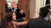 Presiden Donald Trump menunjuk ke wartawan CNN, Jim Acosta, sedangkan seorang staf Gedung Putih mengambil mikrofon dari tangan 