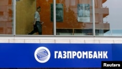 FILE - A person is seen through a window above a Gazprombank branch in Moscow July 17, 2014.
