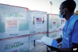 FILE - A worker checks boxes of a coronavirus vaccine following their delivery at the airport in Nairobi, Kenya, Aug. 23, 2021.