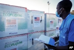 FILE - A worker checks boxes of a coronavirus vaccine following their delivery at the airport in Nairobi, Kenya, Aug. 23, 2021. (AP Photo/Brian Inganga, File)