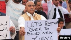 Supporters of Libya's unity government hold signs during a demonstration at Martyrs' Square in Tripoli, April 1, 2016.