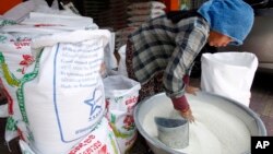 A Cambodian vendor cleans her rice as she prepares it to sell at a rice store in Phnom Penh, Cambodia, Saturday, April 27, 2019.