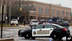 A law enforcement officer walks in front of Great Mills High School, the scene of a shooting, March 20, 2018, in Great Mills.