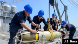 美军安提坦号巡洋舰上的水兵们2018年5月15日在舰上安装鱼雷（美国海军）