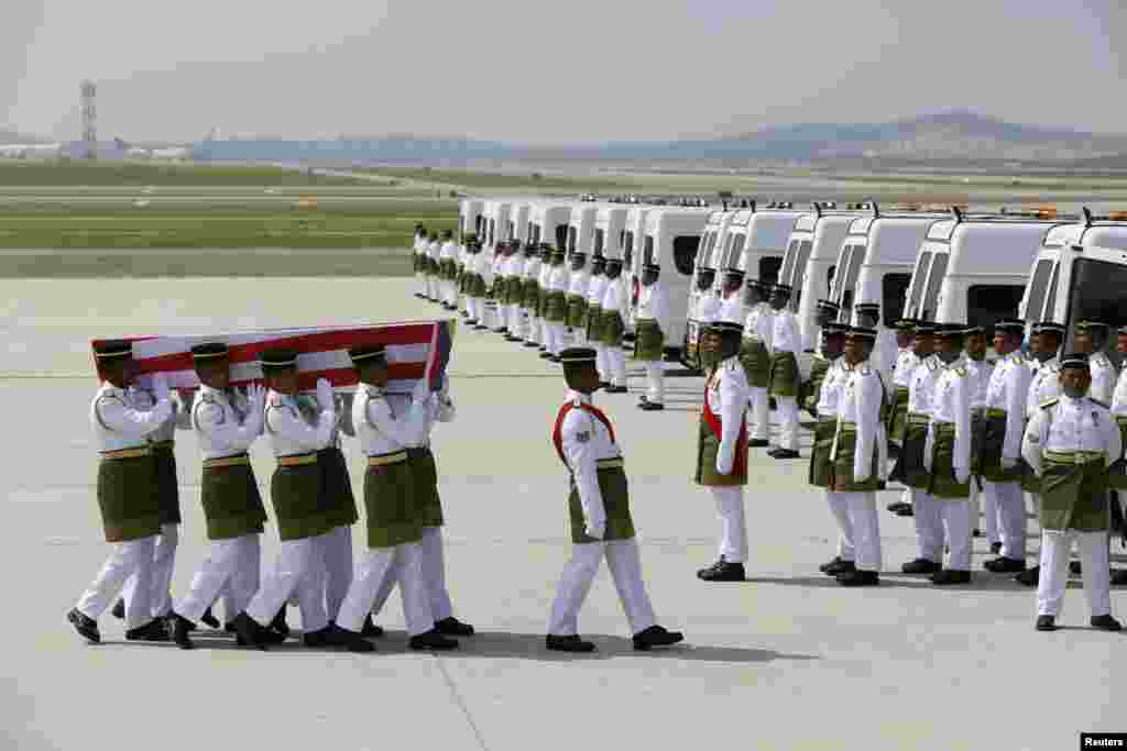 The remains of a passenger of the downed Malaysia Airlines MH17 is carried to a hearse, at the Bunga Raya complex of KLIA airport, in Sepang, Malaysia, Aug. 22, 2014.