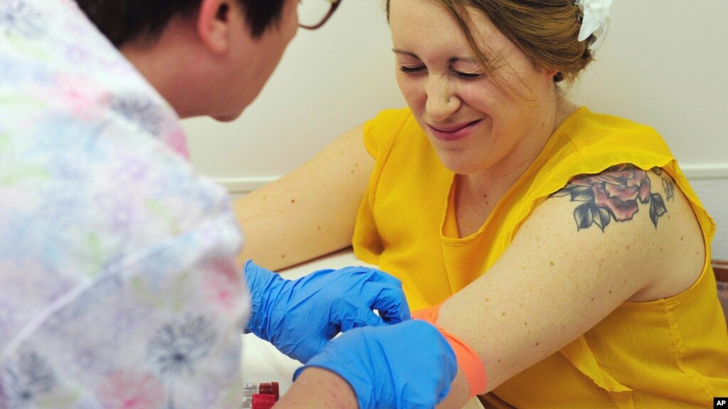 A nurse draws blood from Heidi Wyandt, March 29, 2017. Wyandt is helping test an experimental non-opioid pain medication. 