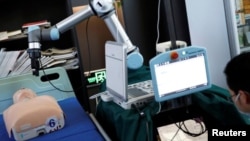 This photo shows a robot designed to help medical workers treat coronavirus patients remotely is pictured during a demonstration for the media at the aerospace engineering school of Tsinghua University in Beijing, China March 4, 2020. (REUTERS/Carlos Garc
